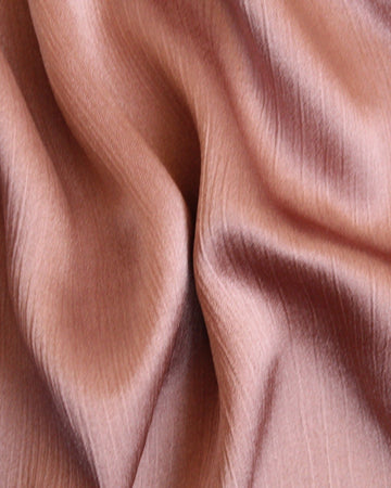 A close-up image of a Luxe Silk Melon hijab, showing its texture and soft color.